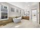 Luxurious bathroom featuring a standalone tub, vanity, and ample natural light from large windows at 6529 Still Pine Cir, Castle Pines, CO 80108