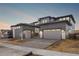 Modern two-story home with gray siding, stone accents, a two-car garage, and professionally landscaped yard at 6529 Still Pine Cir, Castle Pines, CO 80108