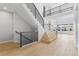 Spacious foyer showcasing an open floor plan, light wood floors and staircase with modern black metal railings at 6529 Still Pine Cir, Castle Pines, CO 80108
