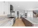 Modern kitchen with stainless steel appliances, white cabinets, marble countertops, dark wood island, and wood floors at 6529 Still Pine Cir, Castle Pines, CO 80108