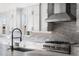 Close up of a modern kitchen featuring white cabinetry, marble countertops, and a stainless steel range and sink at 6529 Still Pine Cir, Castle Pines, CO 80108