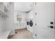 Bright laundry room with white cabinets, modern washer and dryer, and stylish herringbone flooring at 6529 Still Pine Cir, Castle Pines, CO 80108