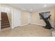 Unfinished basement with tile floor, featuring a stairwell, two entry doors, and a treadmill by the window at 1018 Mulberry Ln, Highlands Ranch, CO 80129