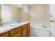 Bathroom featuring double sinks, granite countertops, and a soaking tub with tiled surround at 1018 Mulberry Ln, Highlands Ranch, CO 80129