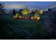 Landscaped backyard at dusk with illuminated trees, creating a serene outdoor ambiance at 7692 Weaver Cir, Castle Rock, CO 80104