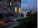 Backyard illuminated with warm lights on the deck and landscaping features at 7692 Weaver Cir, Castle Rock, CO 80104