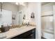 Well-lit bathroom features a mosaic tile backsplash, framed mirror, and a shower with tile surround at 7692 Weaver Cir, Castle Rock, CO 80104