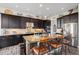 Modern kitchen features an island with breakfast bar and dark cabinets at 7692 Weaver Cir, Castle Rock, CO 80104