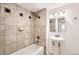 Bathroom featuring a tub shower with decorative tile surround and a pedestal sink with modern lighting at 4730 S Huron St, Englewood, CO 80110