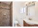 Bathroom featuring a tiled walk-in shower with decorative trim and a modern vanity with a vessel sink at 4730 S Huron St, Englewood, CO 80110
