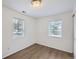 Bedroom with wood-look flooring, white walls, and windows with blinds, offering a simple and clean aesthetic at 4730 S Huron St, Englewood, CO 80110