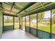 Enclosed porch with green trim, screened windows, and a view of the backyard and adjacent building at 4730 S Huron St, Englewood, CO 80110