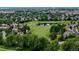 Overhead shot showcasing a golf course community with lush greenery, mature trees, and a tranquil pond at 7038 Russell Ct, Arvada, CO 80007