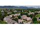 Aerial view of a neighborhood surrounded by lush trees and greenery with a mountain background at 7038 Russell Ct, Arvada, CO 80007