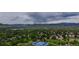 Panoramic aerial view of a neighborhood showcasing green landscapes, mountains, and community tennis courts at 7038 Russell Ct, Arvada, CO 80007