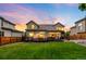 A serene backyard with a lush green lawn, well-kept fence, a charming deck, and a tranquil ambiance at dusk at 7038 Russell Ct, Arvada, CO 80007