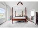 Comfortable bedroom with a four-poster bed, soft carpet, and natural light from the window at 7038 Russell Ct, Arvada, CO 80007