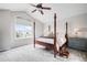 Bright bedroom featuring a four-poster bed, soft carpet, and a large window with neighborhood views at 7038 Russell Ct, Arvada, CO 80007