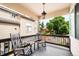 Relaxing covered deck with rocking chairs and a view of the backyard and neighboring homes at 7038 Russell Ct, Arvada, CO 80007