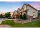 A charming home showcasing a well-maintained lawn, attractive landscaping, and a blend of brick and stucco exterior at 7038 Russell Ct, Arvada, CO 80007
