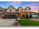 Beautiful two-story home featuring a three-car garage, brick accents, a well-manicured lawn and a cozy front porch at 7038 Russell Ct, Arvada, CO 80007
