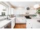 Modern kitchen featuring white cabinets, subway tile backsplash, stainless steel appliances, and hardwood floors at 7038 Russell Ct, Arvada, CO 80007