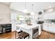 Bright kitchen with white cabinets, stainless steel appliances, large center island and elegant pendant lighting at 7038 Russell Ct, Arvada, CO 80007