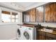 Well-lit laundry room with wood countertop, sink, washer and dryer providing convenience and functionality at 7038 Russell Ct, Arvada, CO 80007