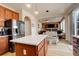 Open concept kitchen featuring an island, stainless steel appliances, and a view into the living room at 15675 E Kettle Pl, Centennial, CO 80112