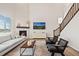 Bright living room with a stone fireplace, a comfortable couch, and a staircase with wooden banisters at 490 Silver Rock Trl, Castle Rock, CO 80104