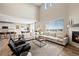Spacious living room with vaulted ceilings, a large sectional sofa, a modern fireplace, and beautiful views at 490 Silver Rock Trl, Castle Rock, CO 80104
