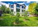 Beautiful backyard with mature trees, green lawn and a deck at 10890 Willow Reed West Cir, Parker, CO 80134