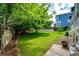 Expansive backyard featuring lush green grass, mature trees, play area, and privacy fence at 10890 Willow Reed West Cir, Parker, CO 80134