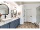 A bright bathroom featuring a dual sink vanity with updated fixtures and a shower behind a glass door at 10890 Willow Reed West Cir, Parker, CO 80134
