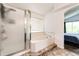 Bright bathroom featuring a shower, tub, and a large window at 10890 Willow Reed West Cir, Parker, CO 80134