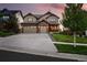 Two-story home boasts a stone facade, attached three-car garage, and a covered porch at 7949 S Elk Way, Aurora, CO 80016
