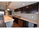 Kitchen featuring stainless steel appliances, a stylish marble counter, bar seating, and dark cabinets at 7949 S Elk Way, Aurora, CO 80016