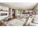 Open-concept living room with hardwood floors, fireplace and adjacent kitchen at 7949 S Elk Way, Aurora, CO 80016