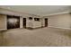 Large carpeted living room with a bar and hardwood floors, perfect for entertaining and featuring a barn door at 7949 S Elk Way, Aurora, CO 80016