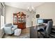 Inviting home office space with ample seating, storage, and a decorative display cabinet at 7949 S Elk Way, Aurora, CO 80016
