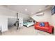 Cozy bedroom with sloped ceilings, bright lighting, and a comfortable red couch at 3825 Tejon St, Denver, CO 80211