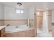 Well-lit bathroom featuring a deep soaking tub and a separate shower at 60 Yarrow St, Lakewood, CO 80226