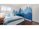 Charming bedroom features a fun mountain-themed mural, hardwood floors, and plenty of natural light at 60 Yarrow St, Lakewood, CO 80226