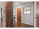 Welcoming entryway features hardwood floors, a red brick accent wall, and natural light at 60 Yarrow St, Lakewood, CO 80226