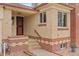 Close up view of front entryway with brick accents and tiled stairs at 60 Yarrow St, Lakewood, CO 80226