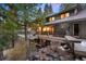 Spacious back deck with outdoor seating and a view of the forest at 3816 Spring Valley Trl, Evergreen, CO 80439