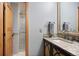 Well-lit bathroom showcasing granite countertops, custom wood cabinets, and a glass-enclosed shower at 3816 Spring Valley Trl, Evergreen, CO 80439