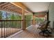 Covered wooden deck with seating, offering a serene view of the surrounding lush greenery at 3816 Spring Valley Trl, Evergreen, CO 80439