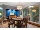 Elegant dining room boasting a round table, chandelier, and a large window with wooded views at 3816 Spring Valley Trl, Evergreen, CO 80439