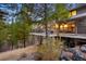 Exterior view of a home with a spacious deck overlooking a forested landscape at 3816 Spring Valley Trl, Evergreen, CO 80439